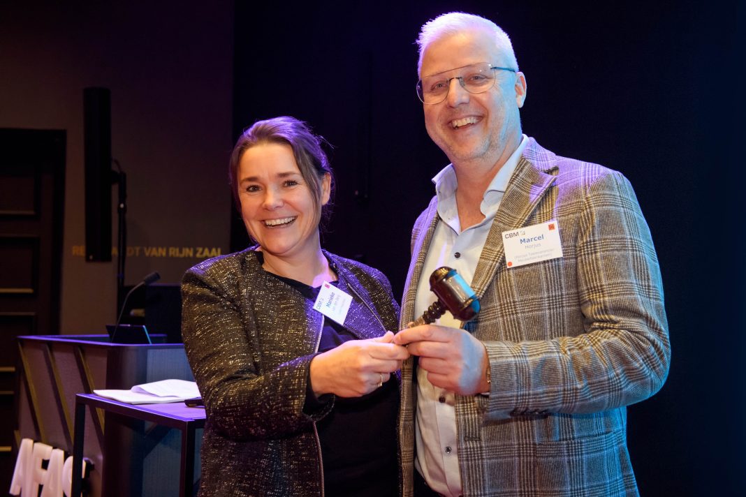 Marcel Horjus overhandigt de voorzittershamer aan Marieke van den Berg