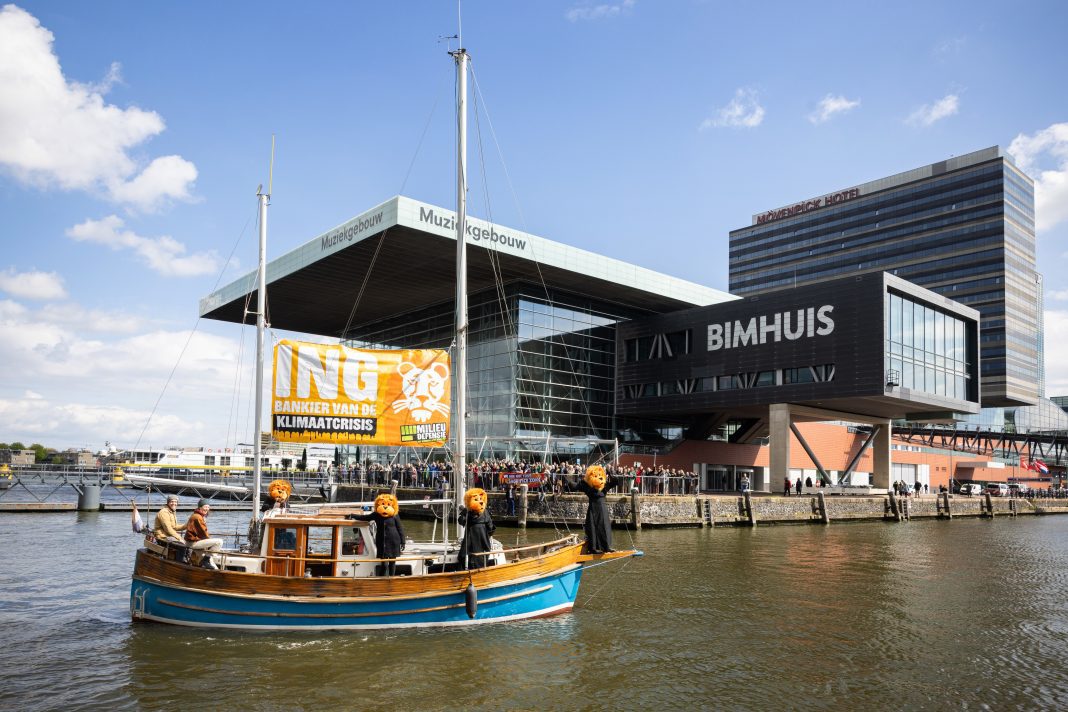 Voor het Muziekgebouw aan ´t IJ voerde een boot met het spandoek: ING, bankier van de klimaatcrisis en stonden oranje leeuwen. (foto: Milieudefensie/Marieke Wijntjes)