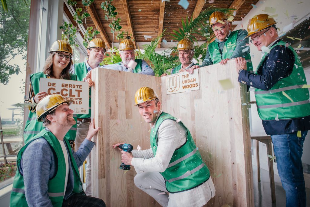 Confetti tijdens de eerste schroef in C-CLT ter wereld. Onder The Urban Woods (Tim Vermeend en Sebastian Monteban) boven vlnr The Urban Climate Architects, Staatsbosbeheer, TNO, Boerboom, TNO, Woodjoint. (foto’s: The Urban Woods)